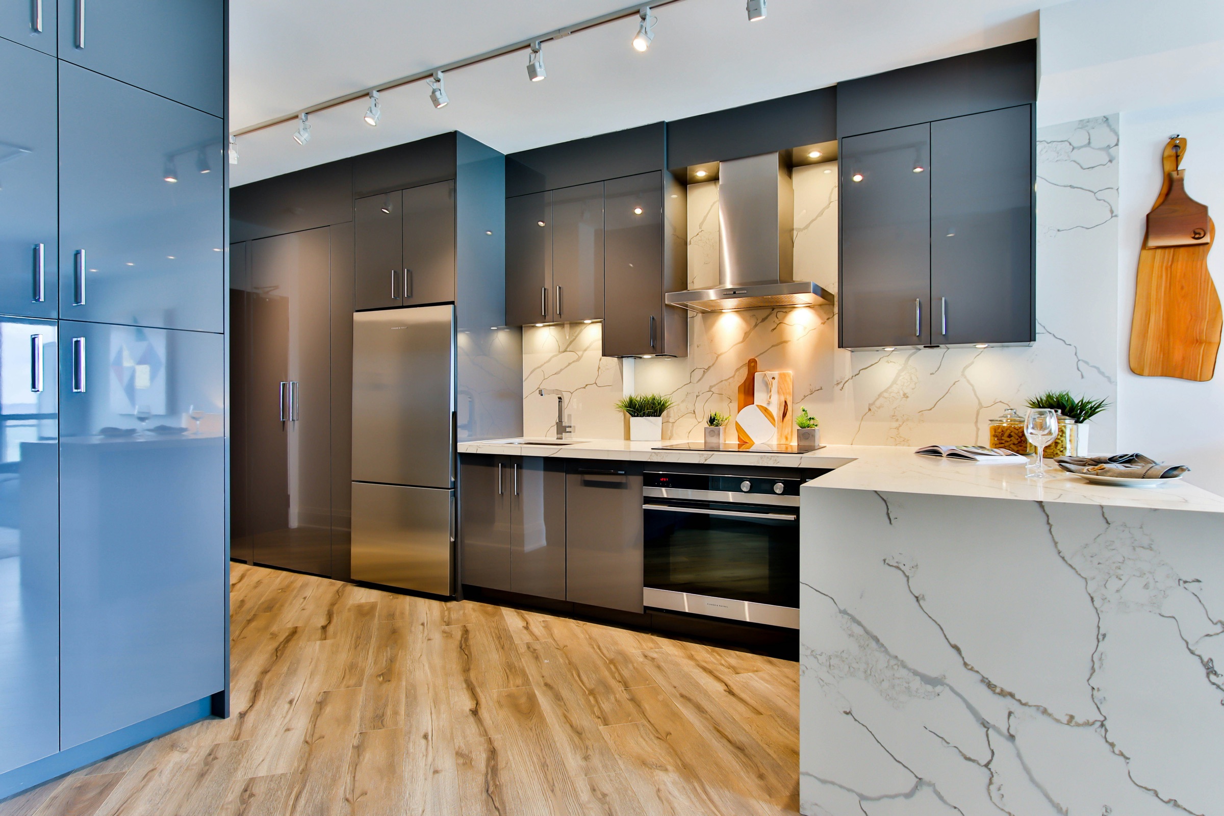 Cocina en gris con isla de mármol y suelo de madera